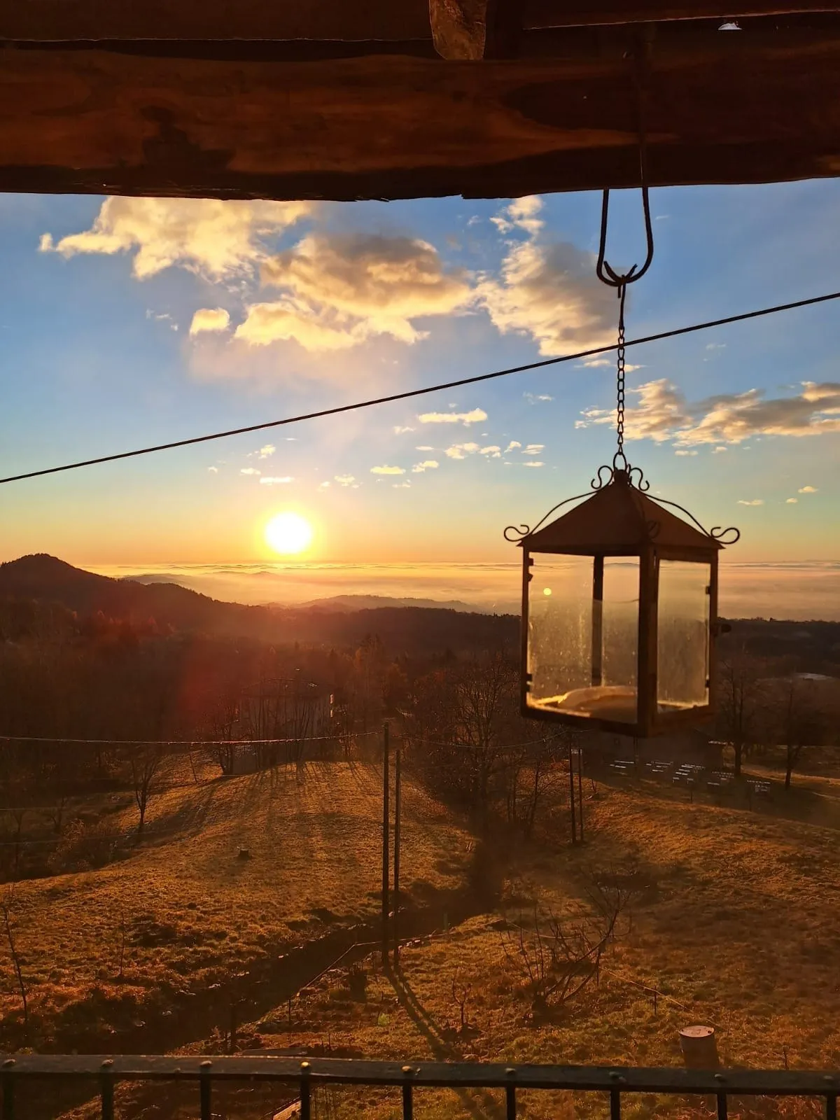 Una lanterna sospesa davanti alle colline al tramonto.